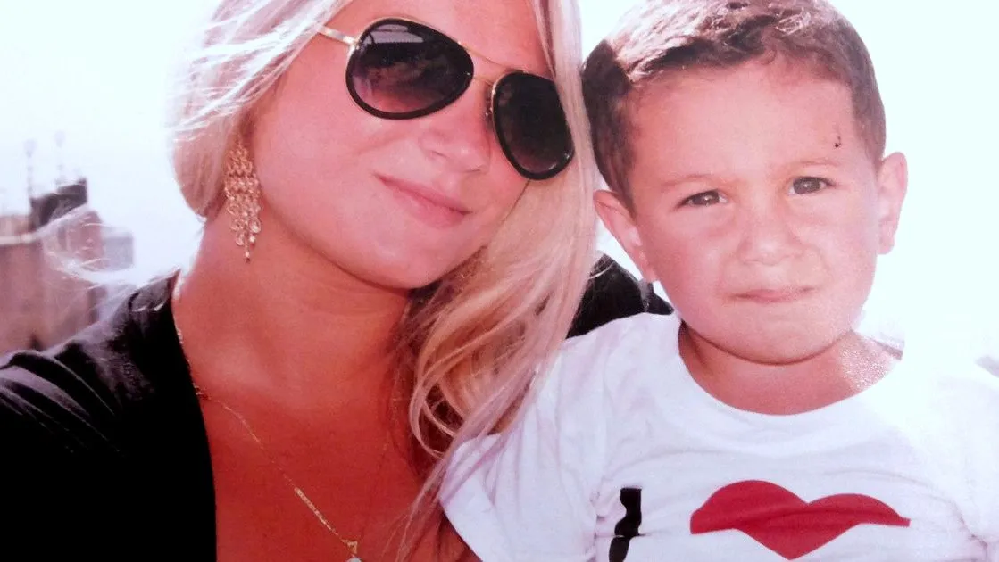 Serena in sunglasses with her young son Ali beside her, in bright sunlight — a family photograph.