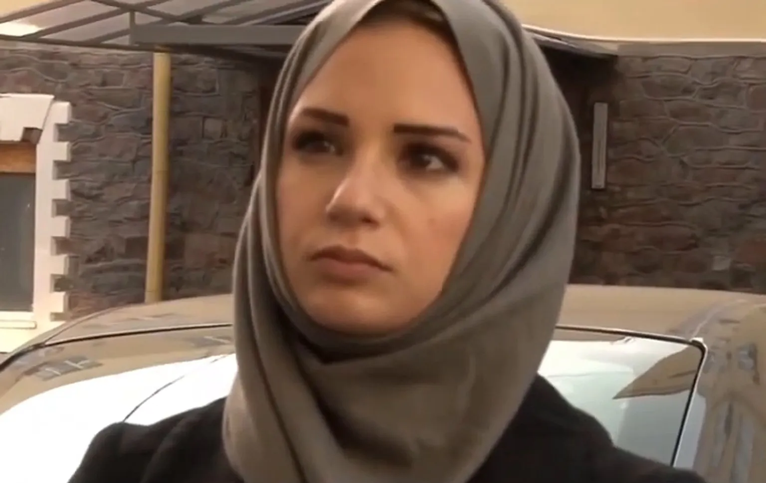 Serena in a grey-green headscarf beside a car near Kobani, October 2014, her gaze calm and to the side — her final assignment.